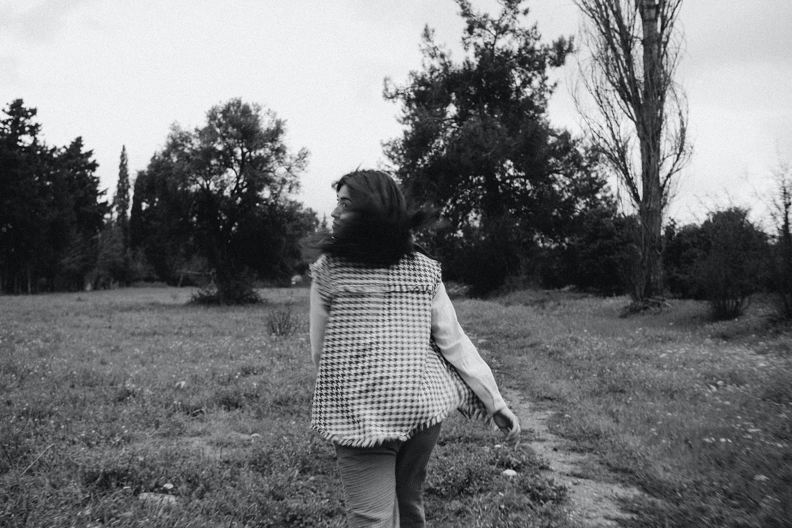 woman walking away through a meadow